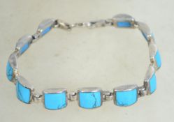 A sterling silver 925 panel bracelet, having turquoise spacers and claw clasp. Measures 8 inches