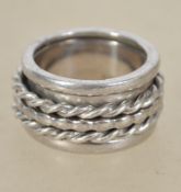 A sterling silver 925 metamorphic band ring of unusual form having three smaller bands to centre.