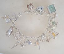 A hallmarked silver charm bracelet having heart padlock clasp, with multiple charms to include £