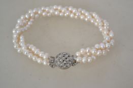 A vintage triple strand freshwater pearl bracelet with modernist box clasp. Measures 23cms long.