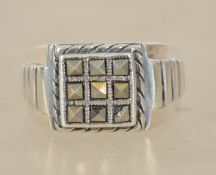 A sterling silver 925 and marcasite signet ring having a central marcasite grid with bevelled border
