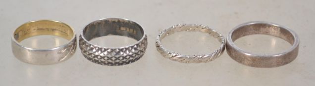 A group of 5 sterling silver rings, 4 being band rings along with a heart shaped signet ring.