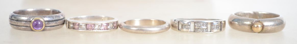 A group of five sterling silver dress rings, one having a central gilt ball, one having a central