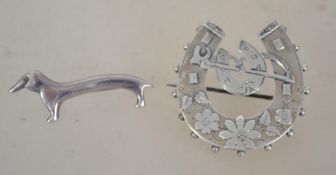 A silver hallmarked horse shoe brooch with foliate decoration with central smaller horse shoe and