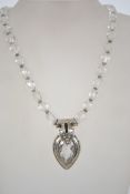 A rock crystal and sterling silver necklace having oval rock crystal beads with silver pendant