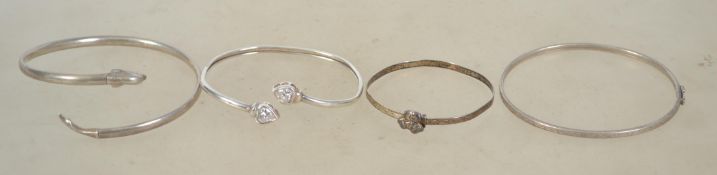 A group of 4 sterling silver 925 bangle bracelets, one having heart shaped rhinestone ends, one