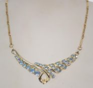 A vintage 1970s rhinestone necklace in a gold tone setting with pale blue rhinestones. Measures