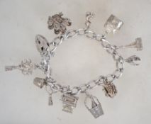 A silver charm bracelet having heart padlock clasp, with multiple charms to include train, pixie,