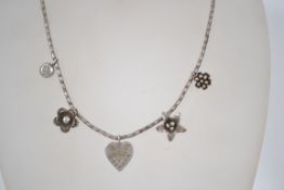 A sterling silver 925 bracelet chain having a S hook clasp and various flower and heart drops.
