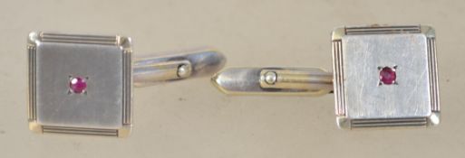 A pair of sterling silver 925 gentleman's cuff links of square form having central garnet stones.