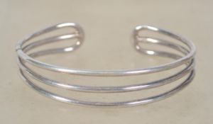 A sterling silver 925 three bar bangle bracelet. Weighs 23.5 grams and measures 7cms wide.