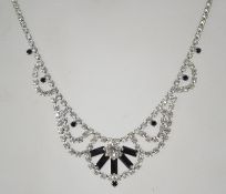 A 1950s iris stripe rhinestone necklace in a silver tone setting with a bolt ring catch. Measures