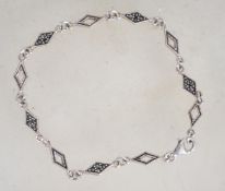A sterling silver 925 marcasite bracelet, having filled and pierced diamond shaped spacers and
