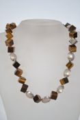 An unusual tigers eye cube and silver necklace chain having a toggle catch. Unmarked tests as silver