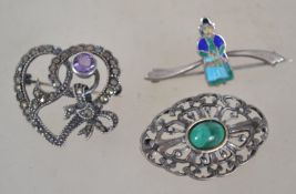A group of three silver brooches one being a marcasite heart bow brooch having pink amethyst