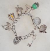 A hallmarked silver charm bracelet having heart padlock clasp, with multiple charms to include