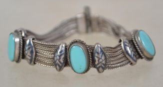 A vintage Turkish silver and turquoise cabochon bracelet with Niello work panels and a pin catch.