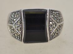 A sterling silver 925 dress ring having a central black onyx panel with stylised marcasite shoulders