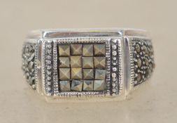 A sterling silver 925 and marcasite signet ring having a central marcasite grid with bevelled border