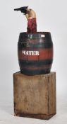 A 20th century unusual fairground attraction - fair prop of a water barrel with cowboy arm and