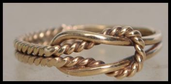 A hallmarked 9ct gold ring in the form of a knot. Hallmarked Birmingham. Size I.5. Weight 1.3g