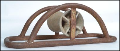 An Industrial mid century tubular wrought metal cable bender. Of arched form with central spinning