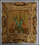 An early 20th century religious Icon, believed Russian with central figure on panel with gilt