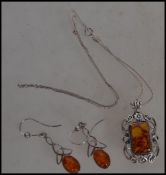 A silver 925 stamped matching amber necklace and earring set, the teardrop amber stones set within