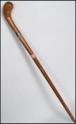 A vintage 20th century walking stick / fish cosh with an over sized terminal above white metal