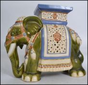 A large elephant ceramic plant stand in green white and blue with plinth top dating to the 20th