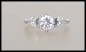 A hallmarked 9ct white gold ring set with a central round cut CZ and accent heart shaped CZ.