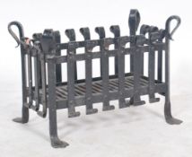 A 20th century ebonised wrought iron open fire grate of basket weave form, with angled feet