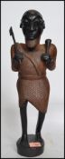 A 20th century large Aboriginal Tribal carving figurine of a warrior holding an axe and spear raised