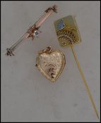 A rolled gold heart shaped locket pendant with etched decoration together with an early 20th century