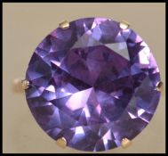 A 9ct gold and sapphire dress ring set with a large prong set sapphire having a pierced gallery.