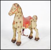 A vintage 20th century Mojo Bronco children's tin plate pedal car type toy horse having painted