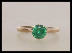 A hallmarked 9ct gold ring set with a single round cut green stone . Hallmarked  Birmingham.  Size