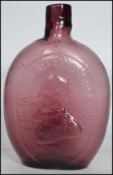 An early 20th century unsual purple glass bottle being moulded and pressed in relief with General