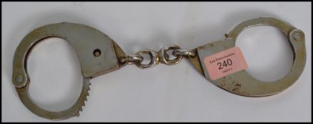 A pair of vintage 20th century pair police issue hand cuffs, the hand cuffs marked PM 2904.