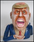 An unusual vintage style Donald Trump money eating money bank having plaque to rear reading grab