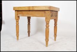 A 19th century scrubbed pine kitchen table having a later butchers block top, raised on turned