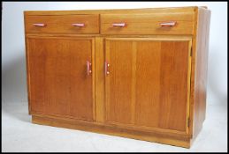 A mid century utility committee style oak sideboar