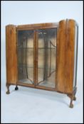 An Art Deco walnut sunburst display cabinet, two doors enclosing a pair of glass shelves, raised