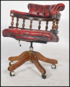 A 20th century ox blood Leather Chesterfield deep button back swivel mahogany framed captains office