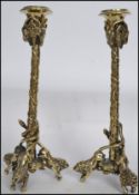 A pair of 19th bell brass lion and goats head candlesticks. Each with rampant lions to the base