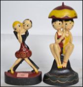 Two vintage Art Deco style cast iron painted doorstops, one in the form of a dancing couple the