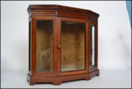 An Edwardian mahogany table top display cabinet bijouterie cabinet of half moon angular form