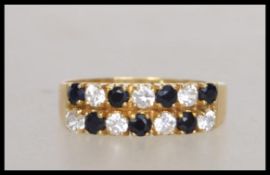 An 18ct gold ring  with pave set sapphire and white stones. Marked 750 tests 18ct gold  . Weight 2.