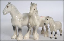 Two Beswick ceramic Shire horses, both in the grey colourway together with a Beswick Shetland pony