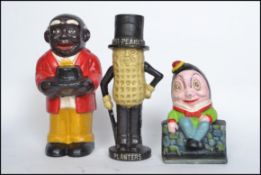 A group of three vintage style cast iron novelty money banks in the form of Smiling Sam, Humpty